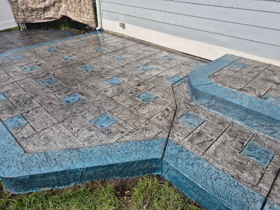 Custom blue-accent stamped patio and steps by General Maintenance Works