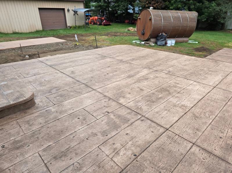 A weathered wood-plank stamped concrete patio by General Maintenance Works in Macomb County