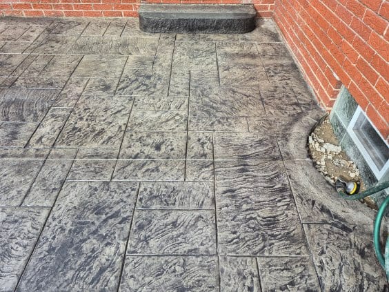 Silver-grey ashlar stamped patio against brick by General Maintenance Works
